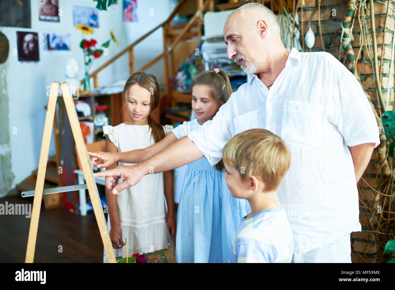 Mature Art Teacher Working with Children Stock Photo