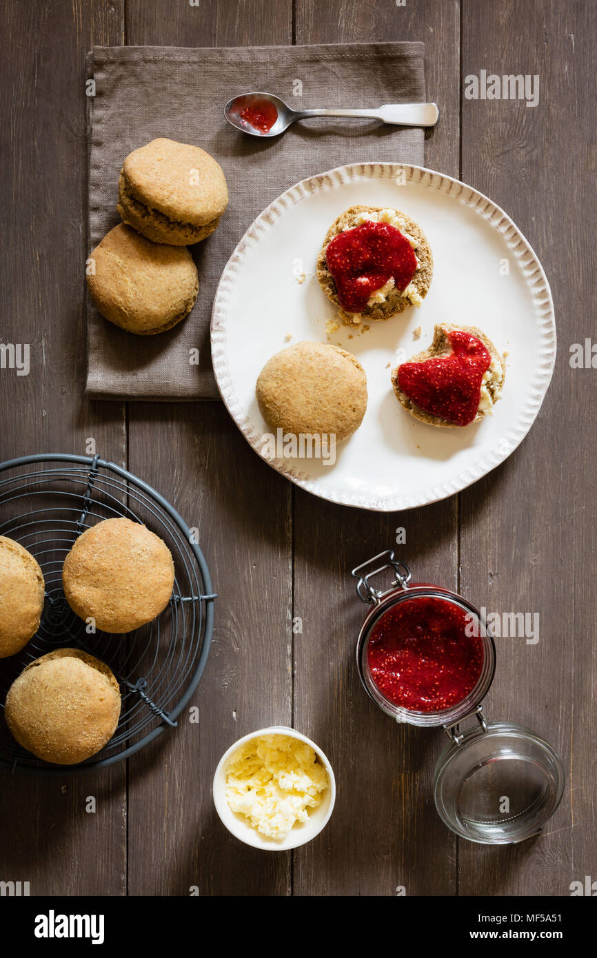 Scones made of einkorn wheat with strawberry jam and clotted cream Stock Photo