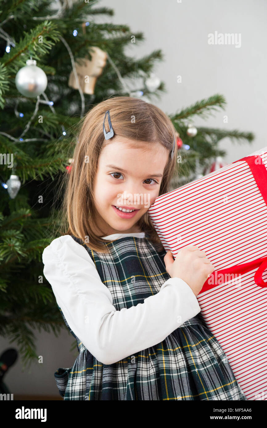 Portrait of smiling little girl holding Christmas present Stock Photo ...