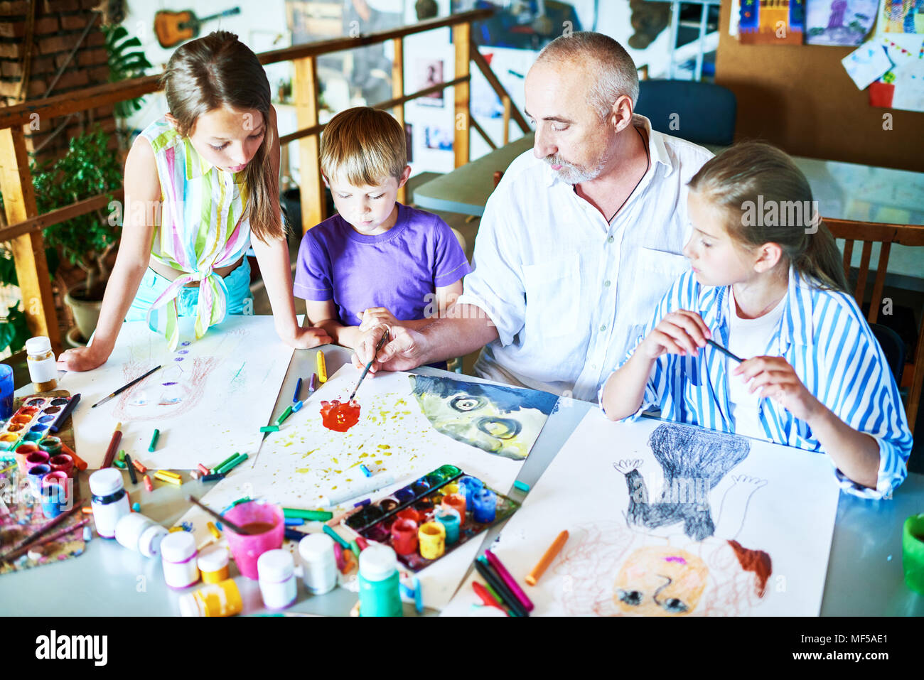 Children Painting with teacher in Art Class Stock Photo - Alamy