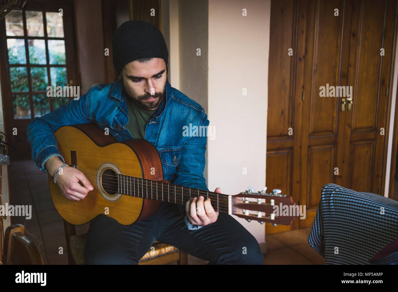 Young man at home playing guitar Stock Photo