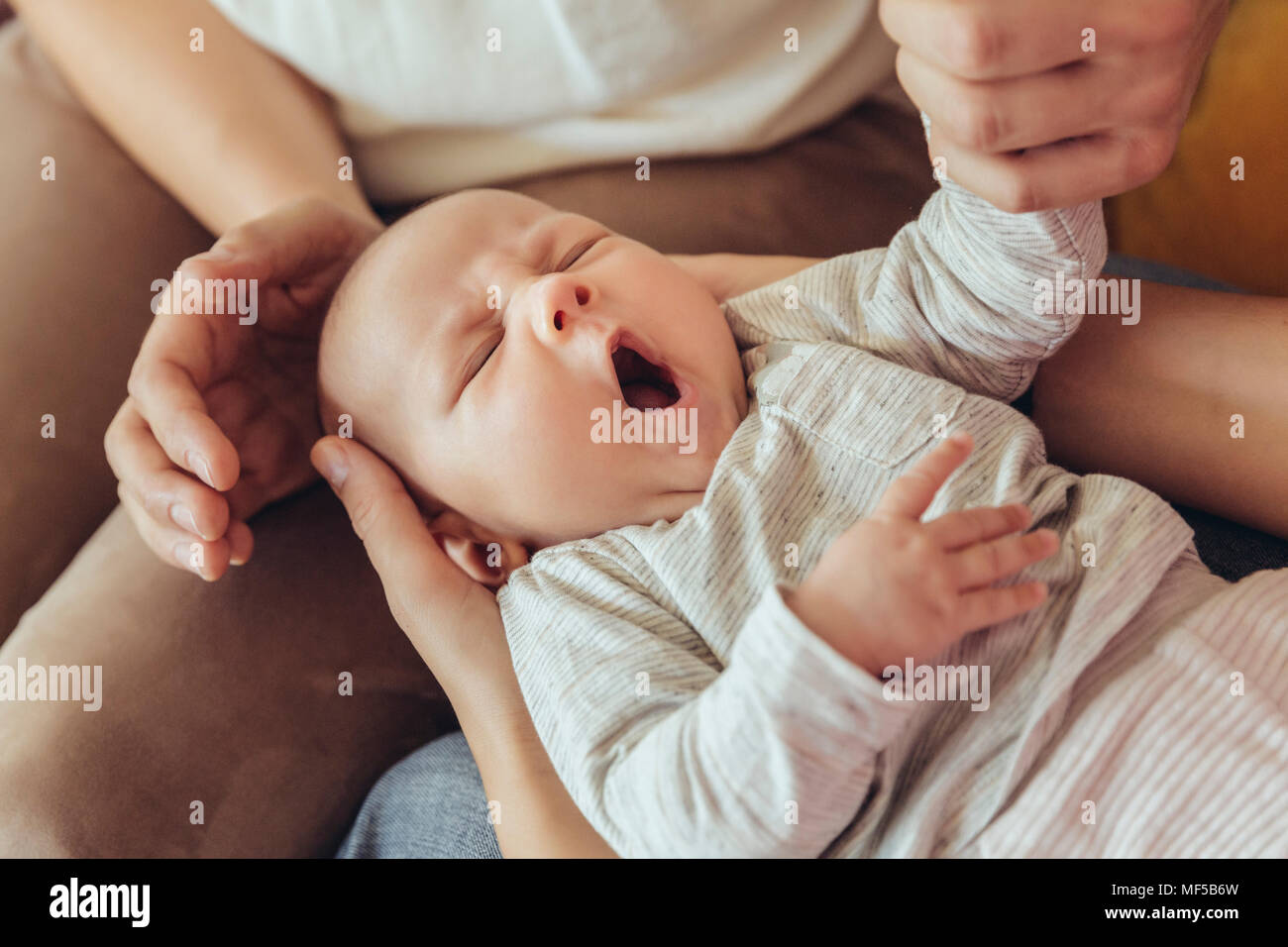 Midwife and mother checking on sleepy newborn baby Stock Photo