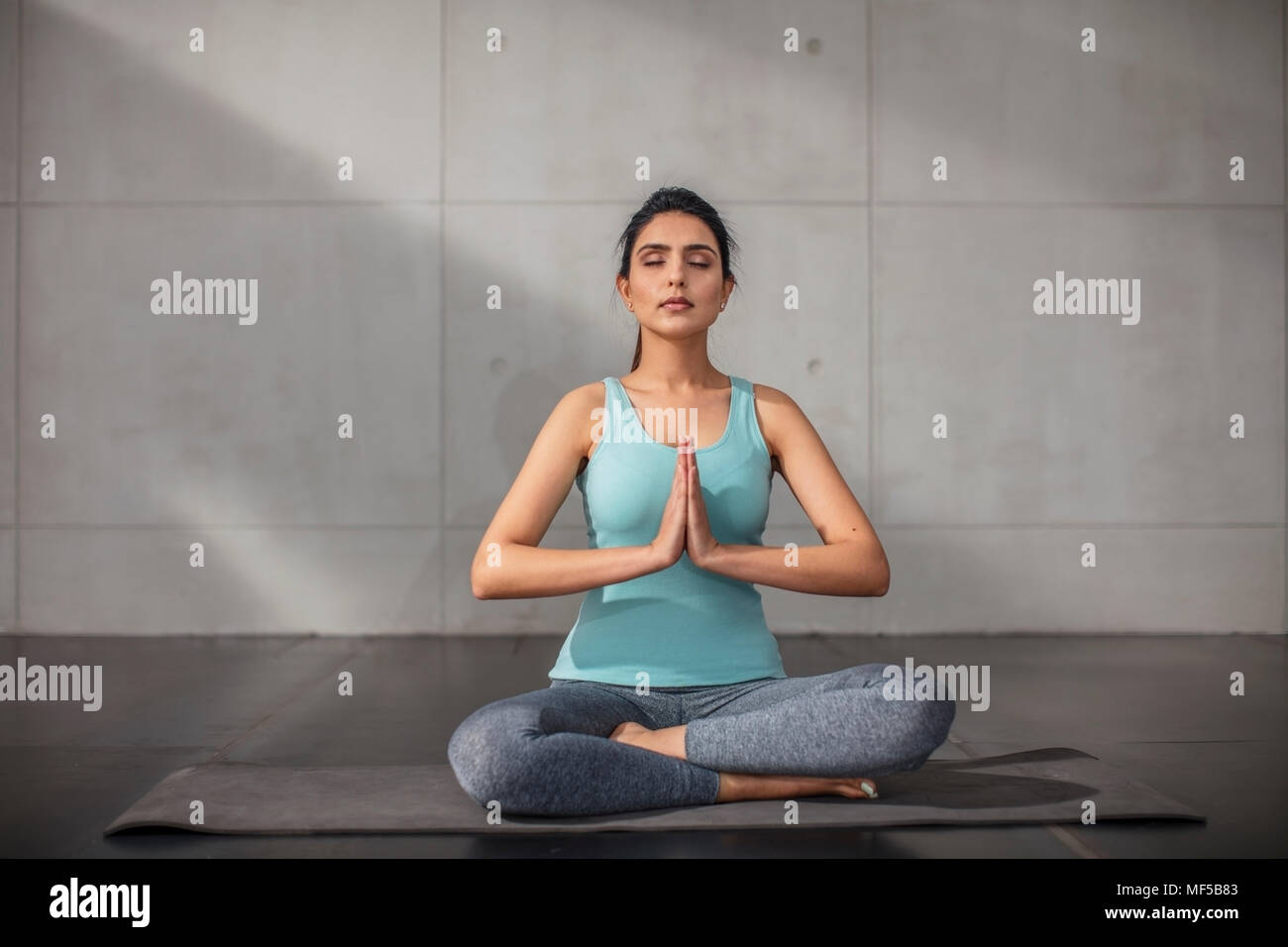 Young woman doing yoga exercise in studio Stock Photo