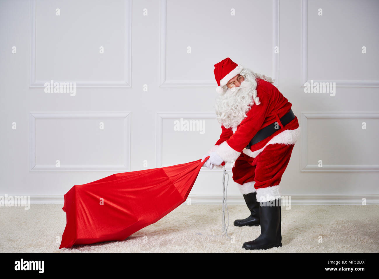 Santa claus pulling heavy sack Stock Photo