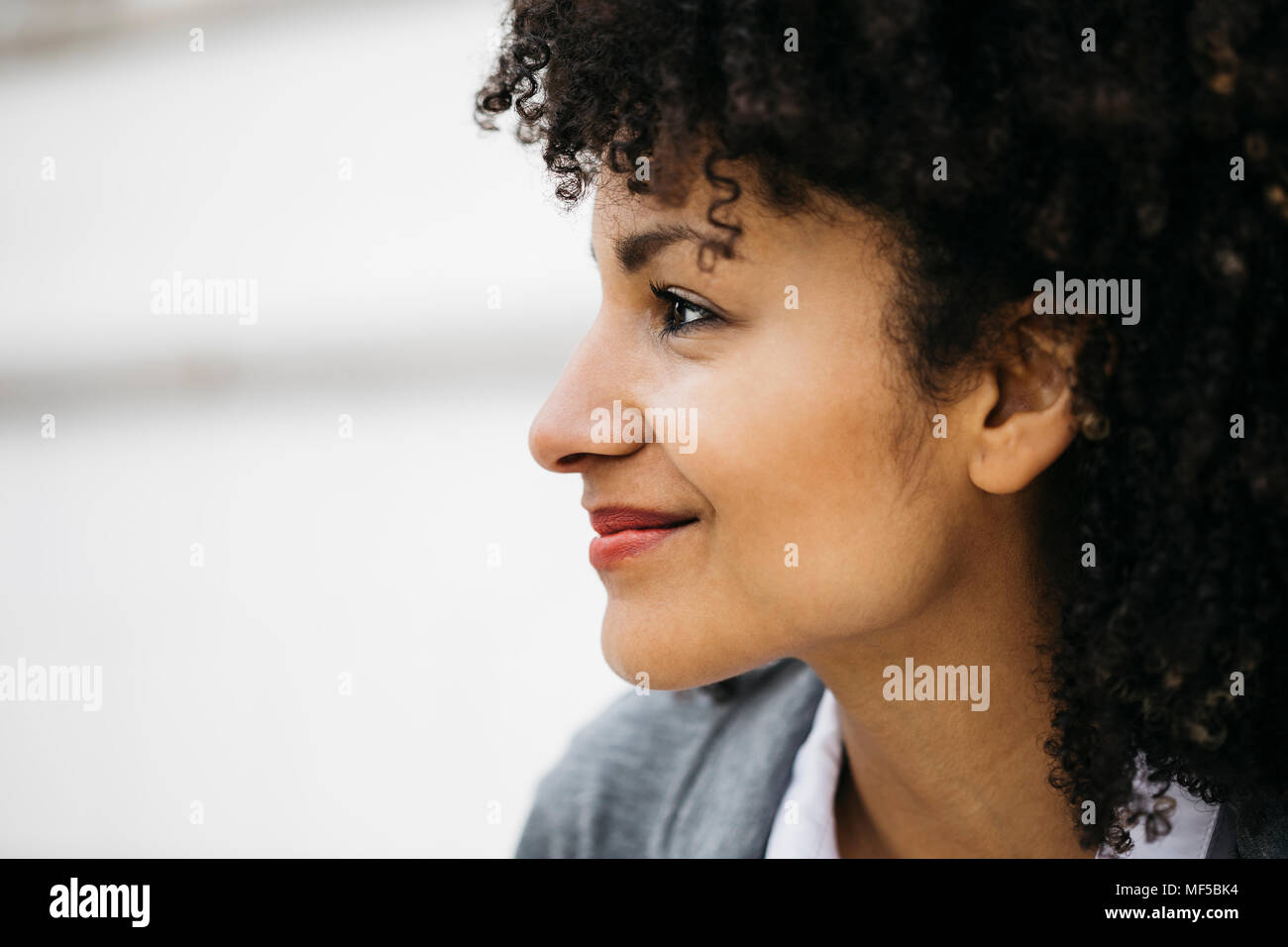Profile of smiling woman with curly hair Stock Photo