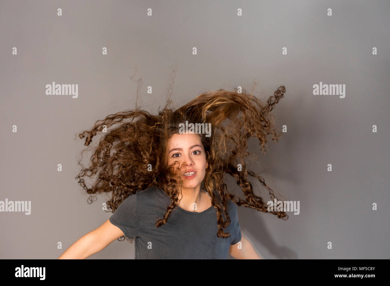 Pretty teenage girl with curly hair, jumping Stock Photo