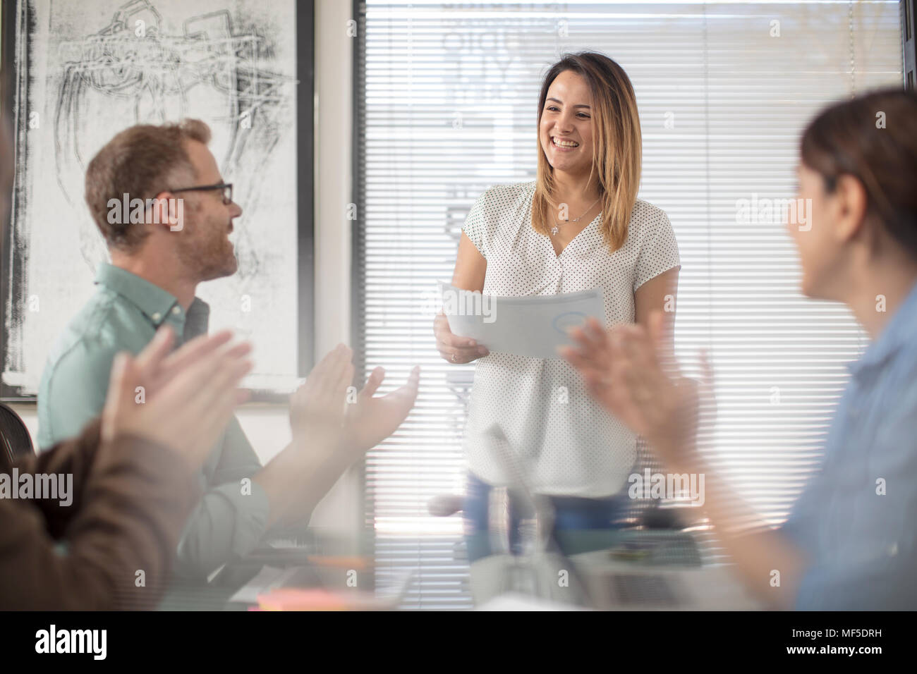 Colleagues applauding or businesswoman on a meeting in office boardroom Stock Photo