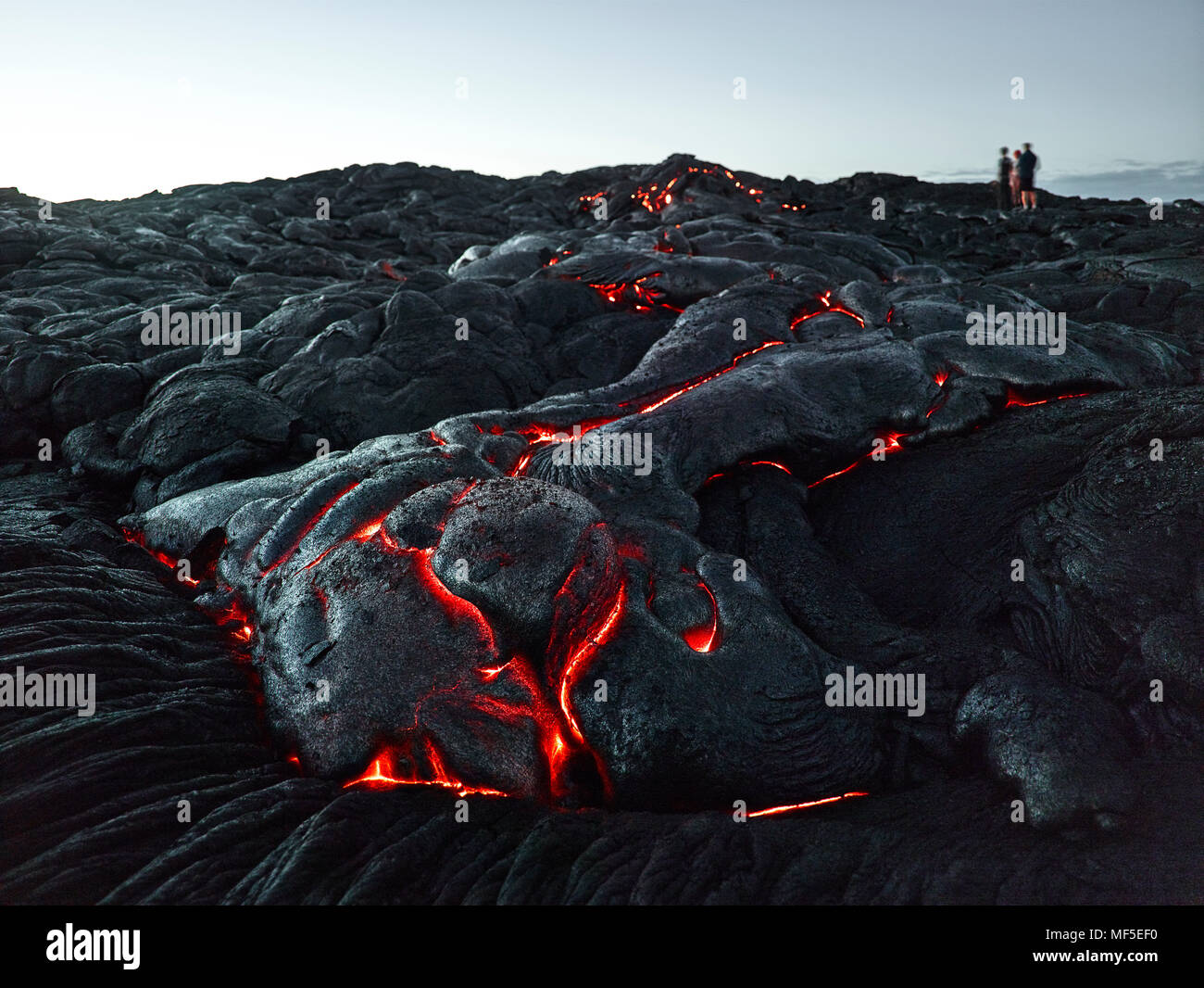 Hawaii, Big Island, Hawai'i Volcanoes National Park, tourists standing on lava field Stock Photo