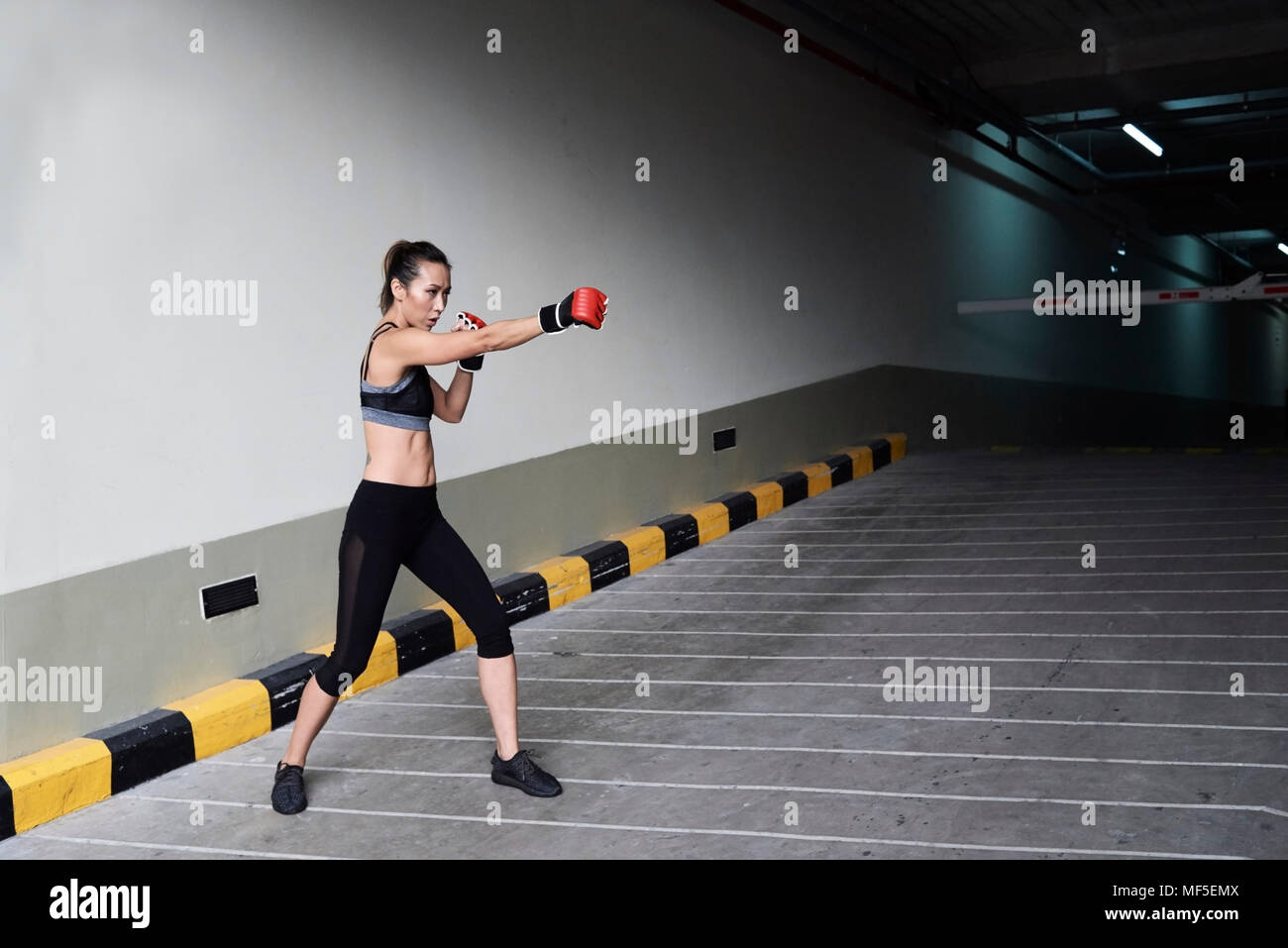 Female boxer boxing in a garage Stock Photo