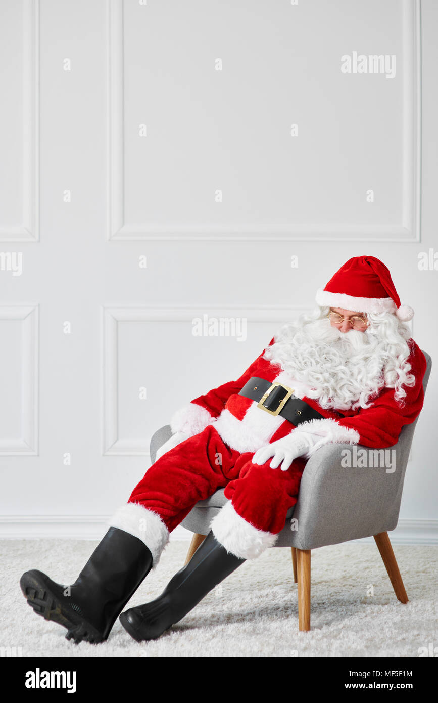 Santa claus sleeping in armchair Stock Photo
