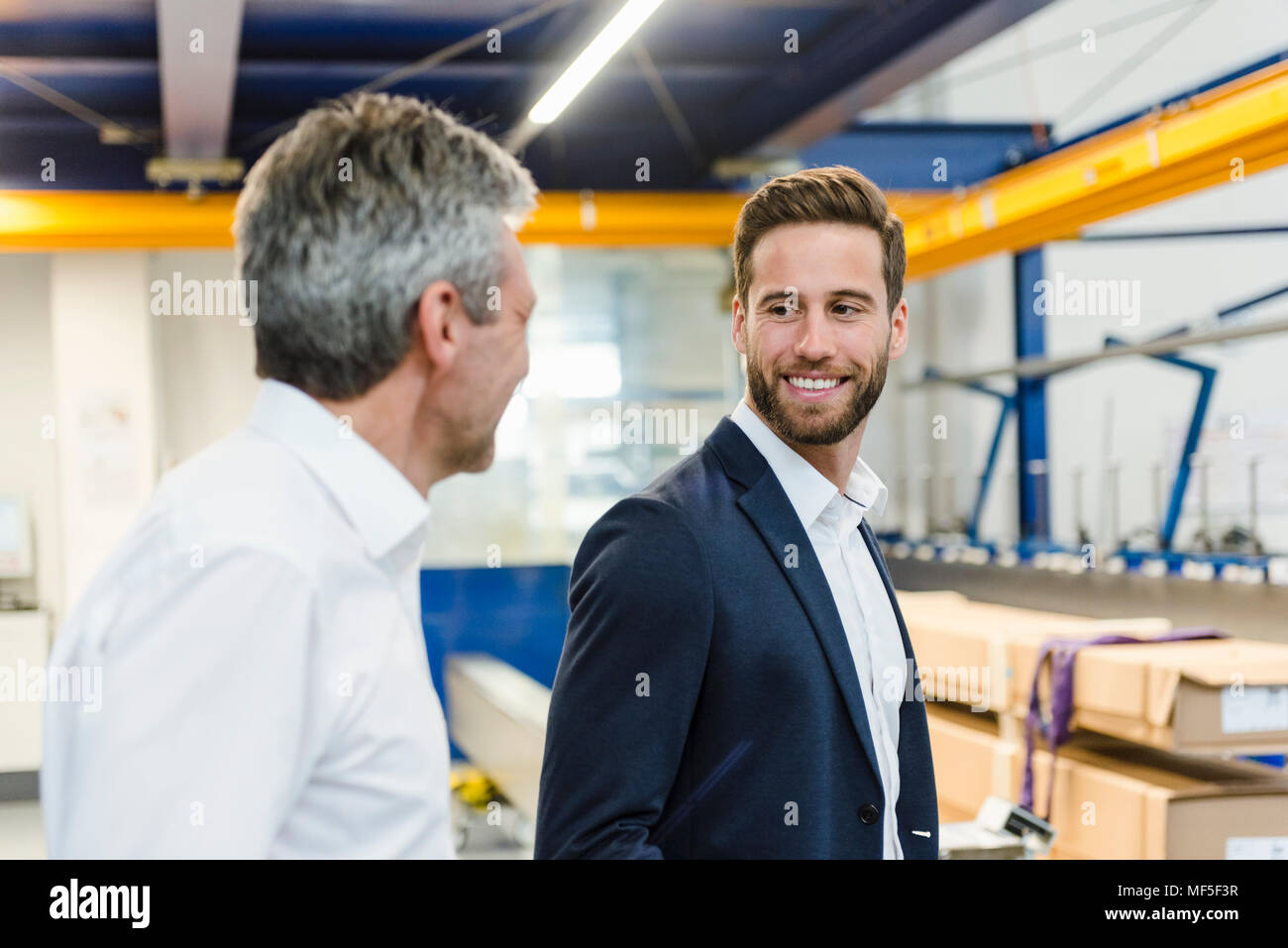 Smiling managers in a production hall Stock Photo