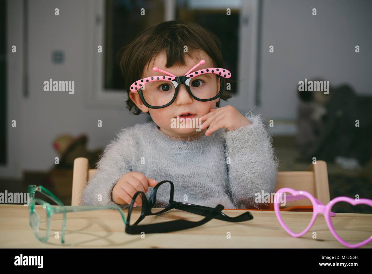 Portrait of baby girl playing with toy glasses Stock Photo