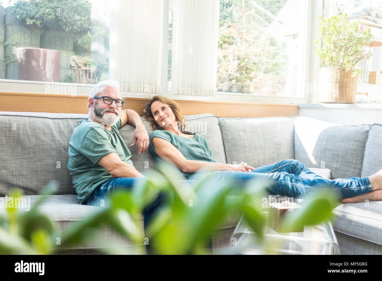 Happy Mixed Race Couple Relax On Couch In Living Room Watch Movie