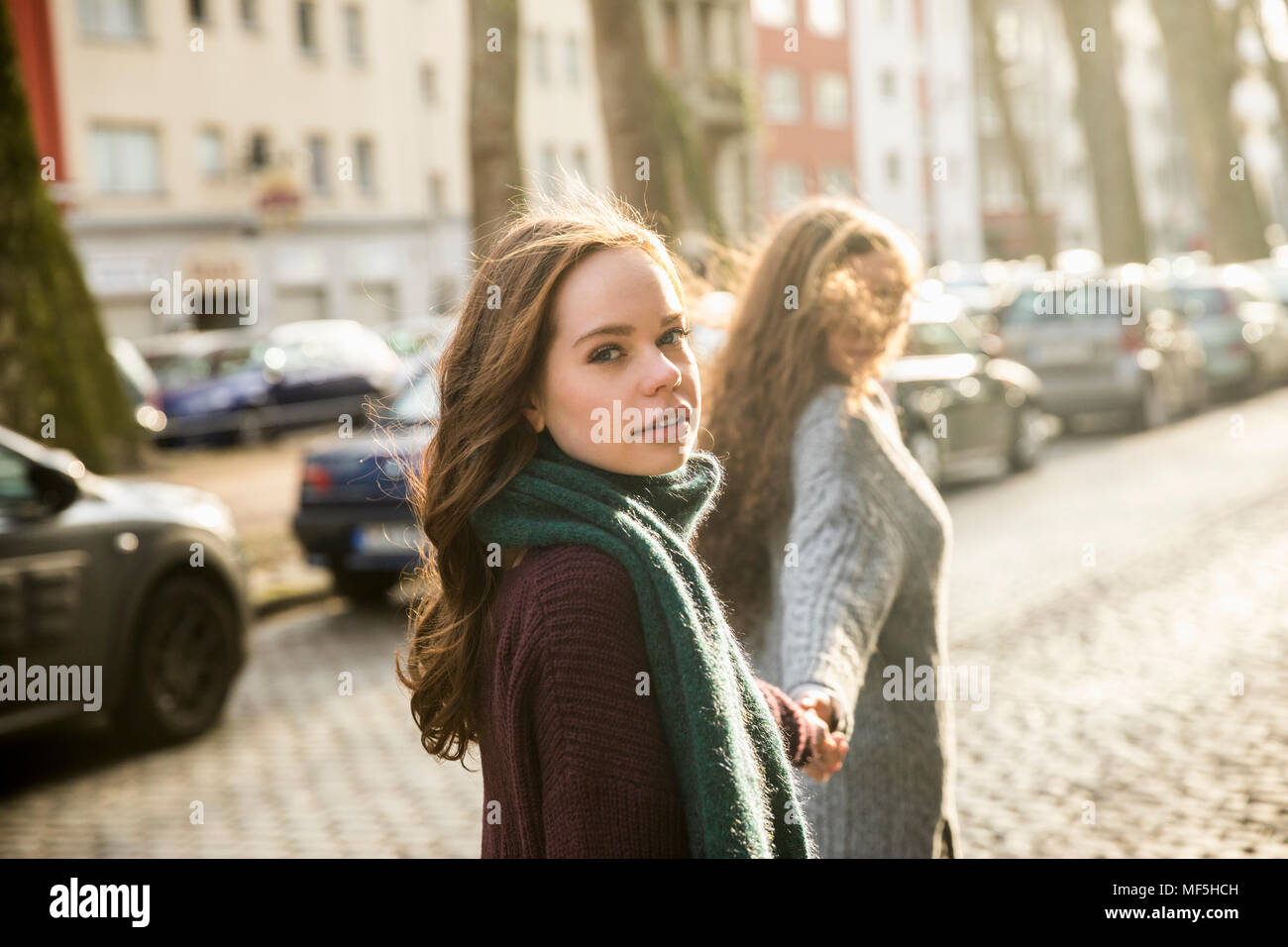 Portrait of teenage girl walking hand in hand with her best friend on the street Stock Photo