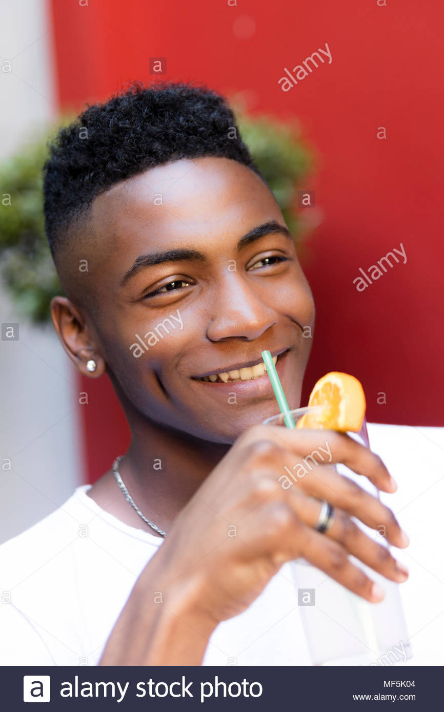 Black Man Relaxed Drinking A Cocktail Outside Stock Photo