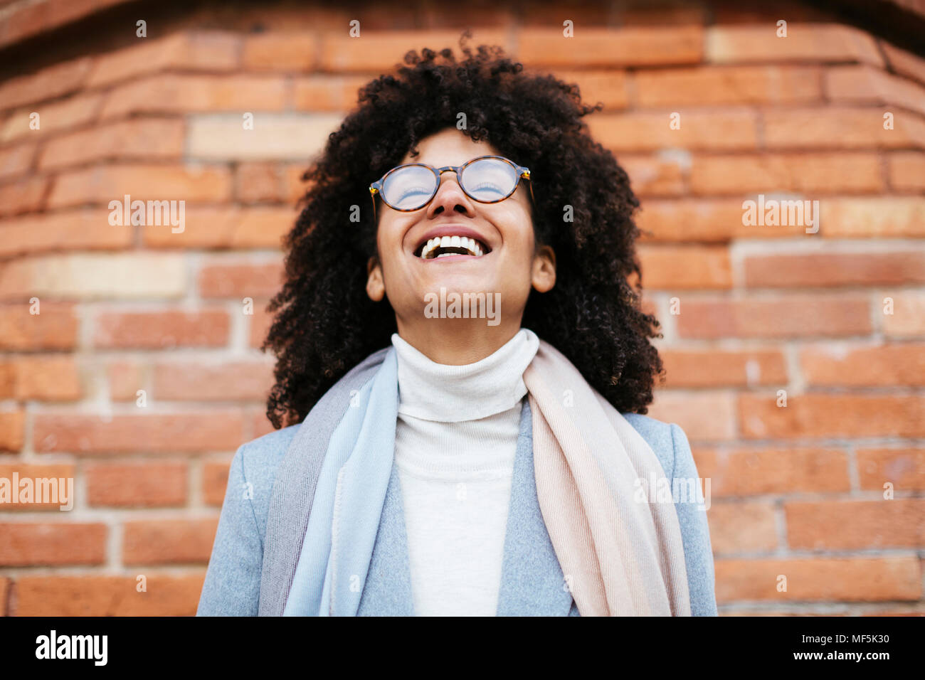 Portrait of laughing woman at brick wall Stock Photo - Alamy
