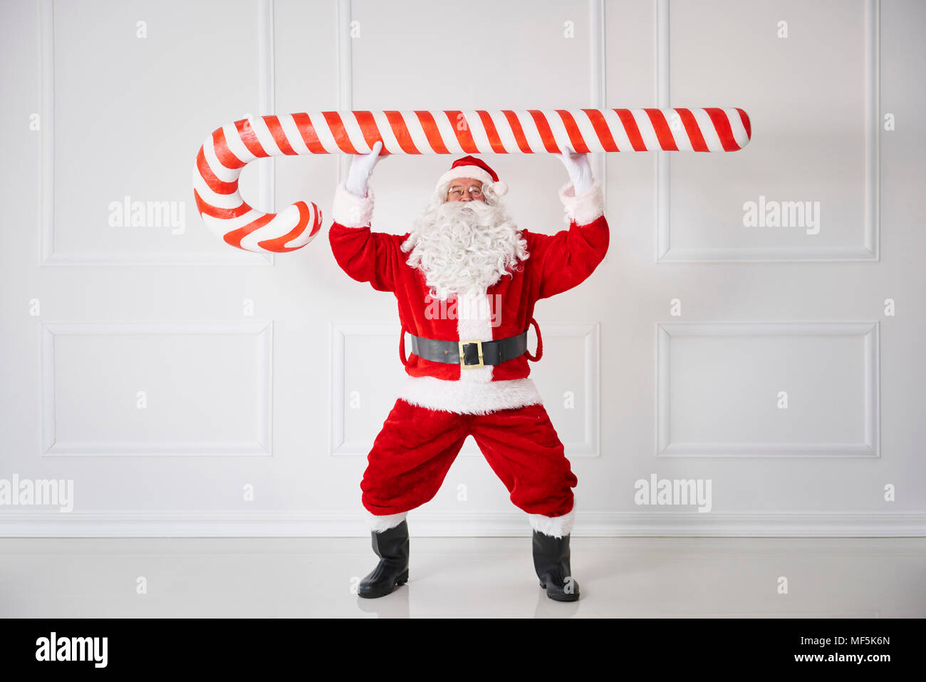Santa Claus with oversized candy cane Stock Photo