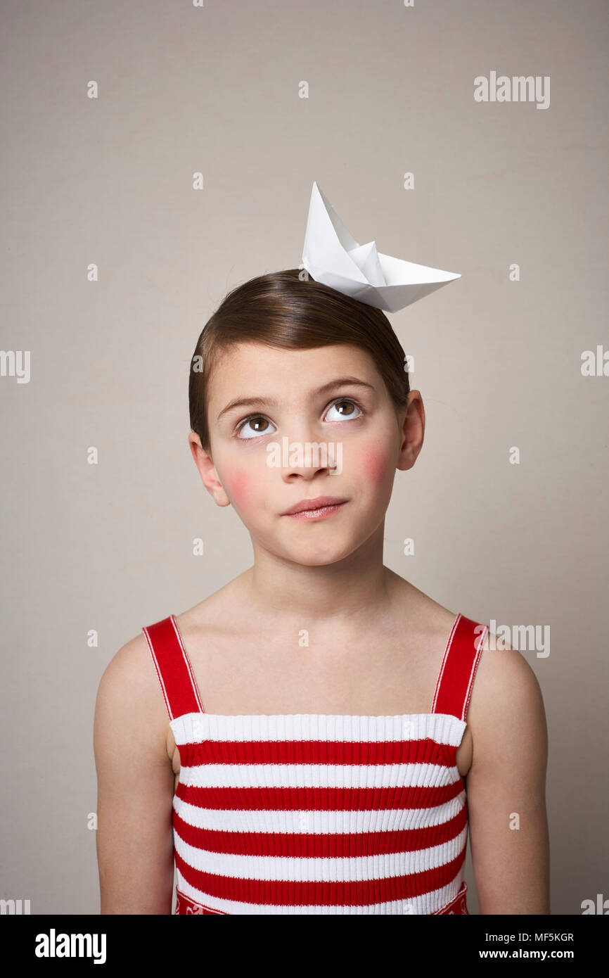 Portrait Of Little Girl With Paper Boat On Her Head Stock