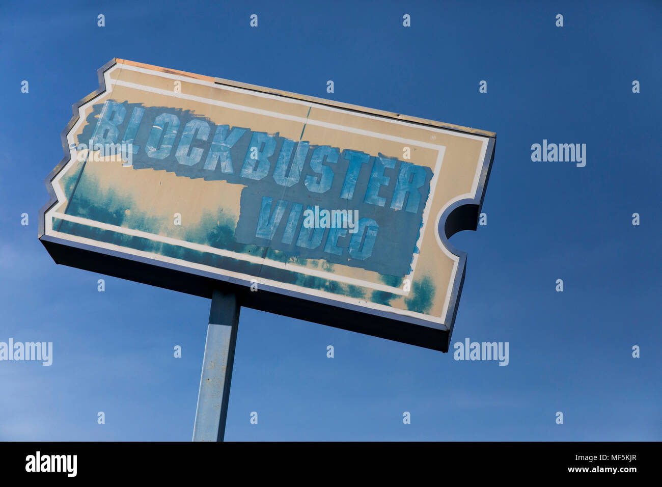 A painted over logo sign outside of a former Blockbuster Video retail ...