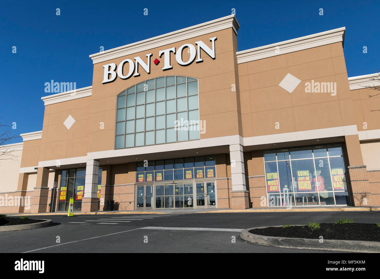 A logo sign outside of a Bon-Ton retail department store in Lancaster, Pennsylvania with 'Going Out Of Business' and 'Store Closing' signage on April  Stock Photo
