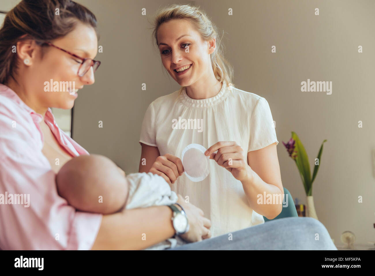 Midwife holding a disposable nursing pad for breastfeeding mother Stock Photo