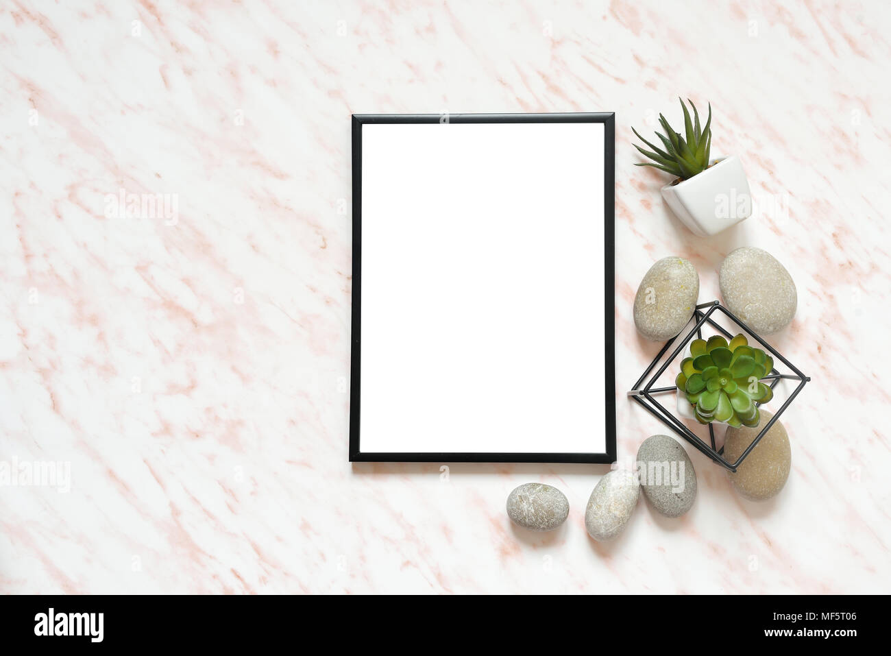Flat lay marble desk with white empty frame for text, stones and succulents background Stock Photo