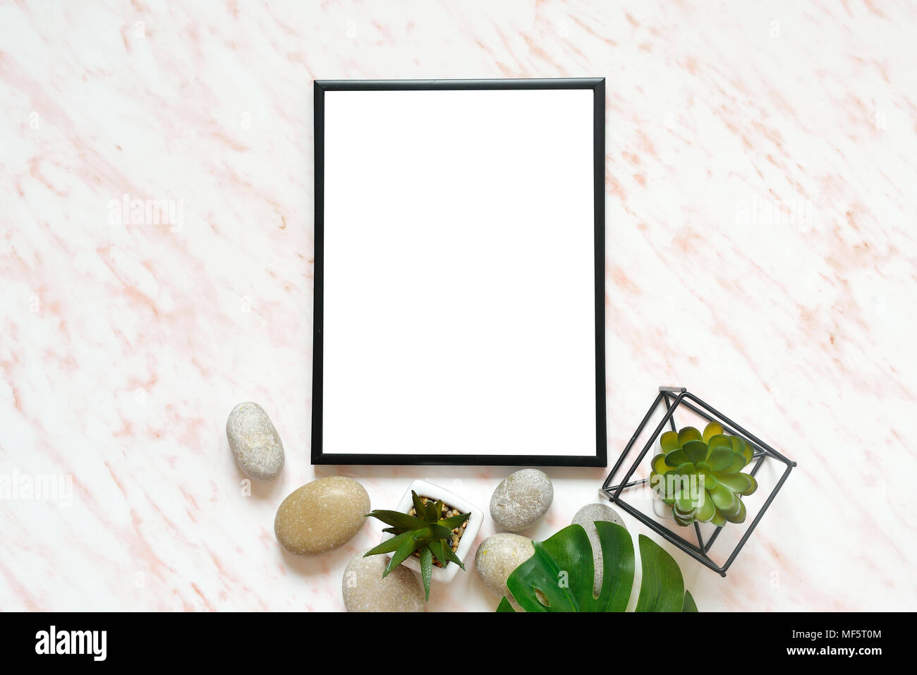 Flat lay marble desk with white empty frame for text, stones and succulents background Stock Photo