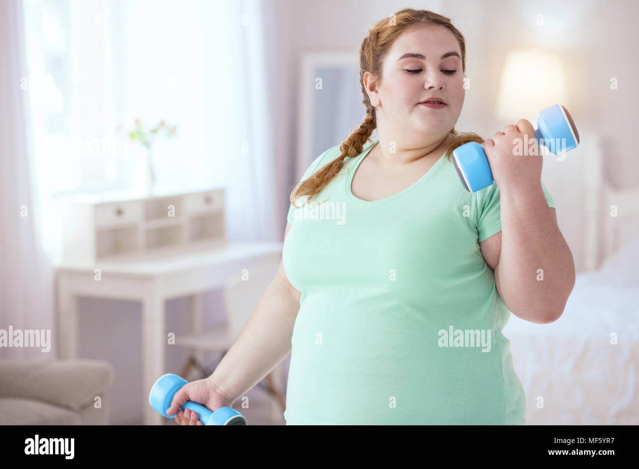 Confident young woman working out at home Stock Photo