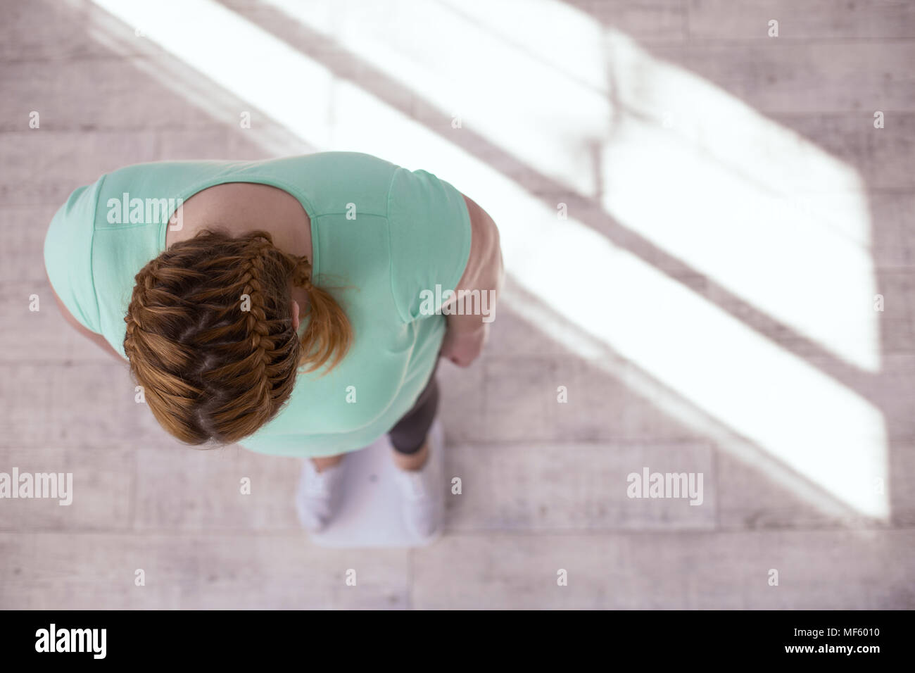 Overweight young woman want to know her weight Stock Photo