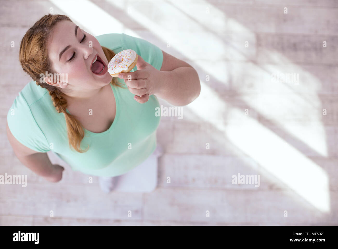 Plump young woman seduced by sweets Stock Photo