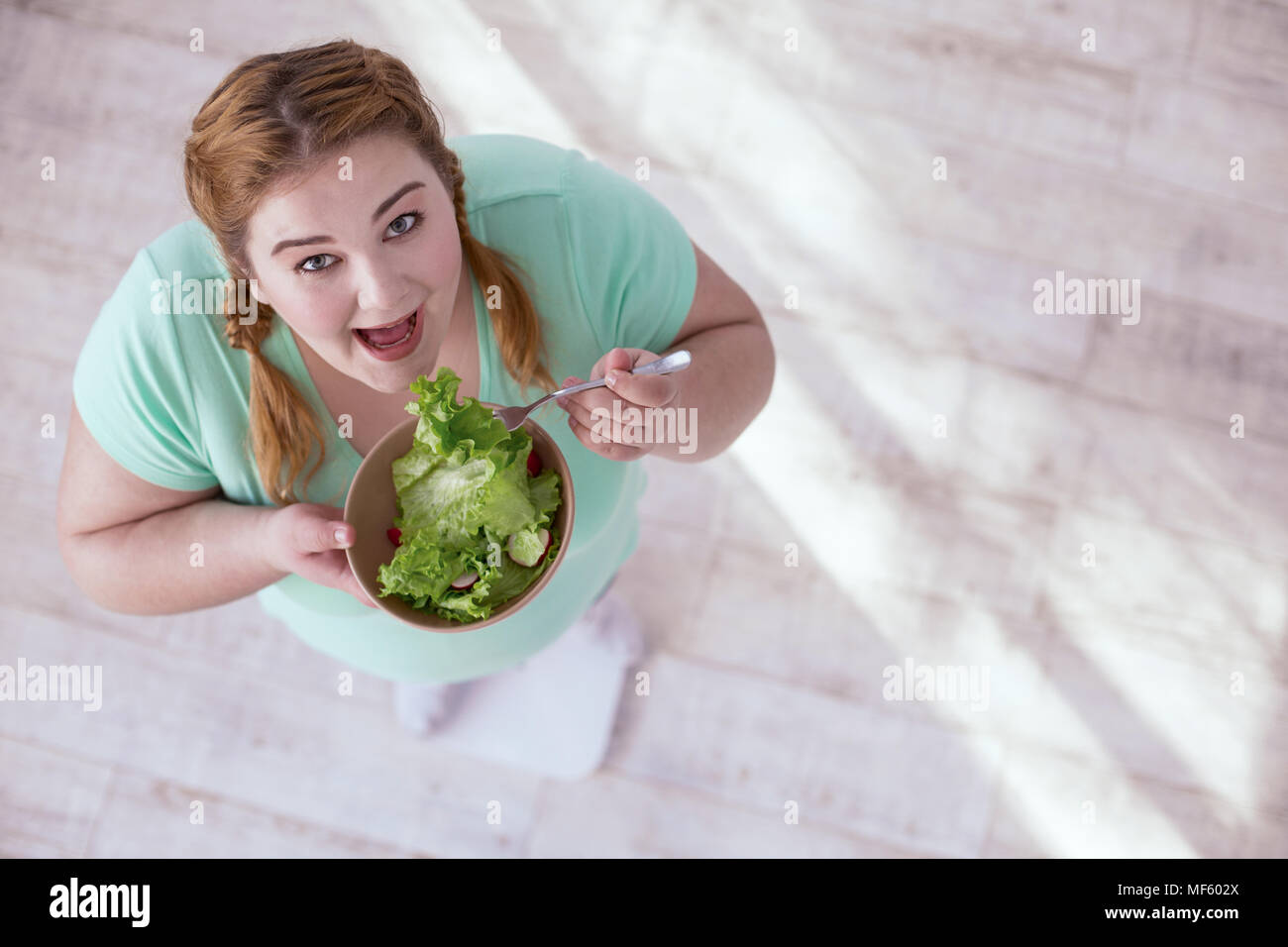 Stout red-head woman eating healthy food Stock Photo