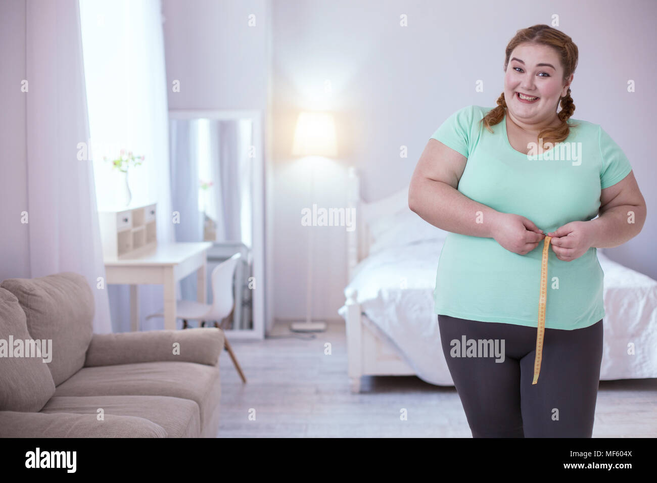 Astonished plump woman estimating her measurements Stock Photo