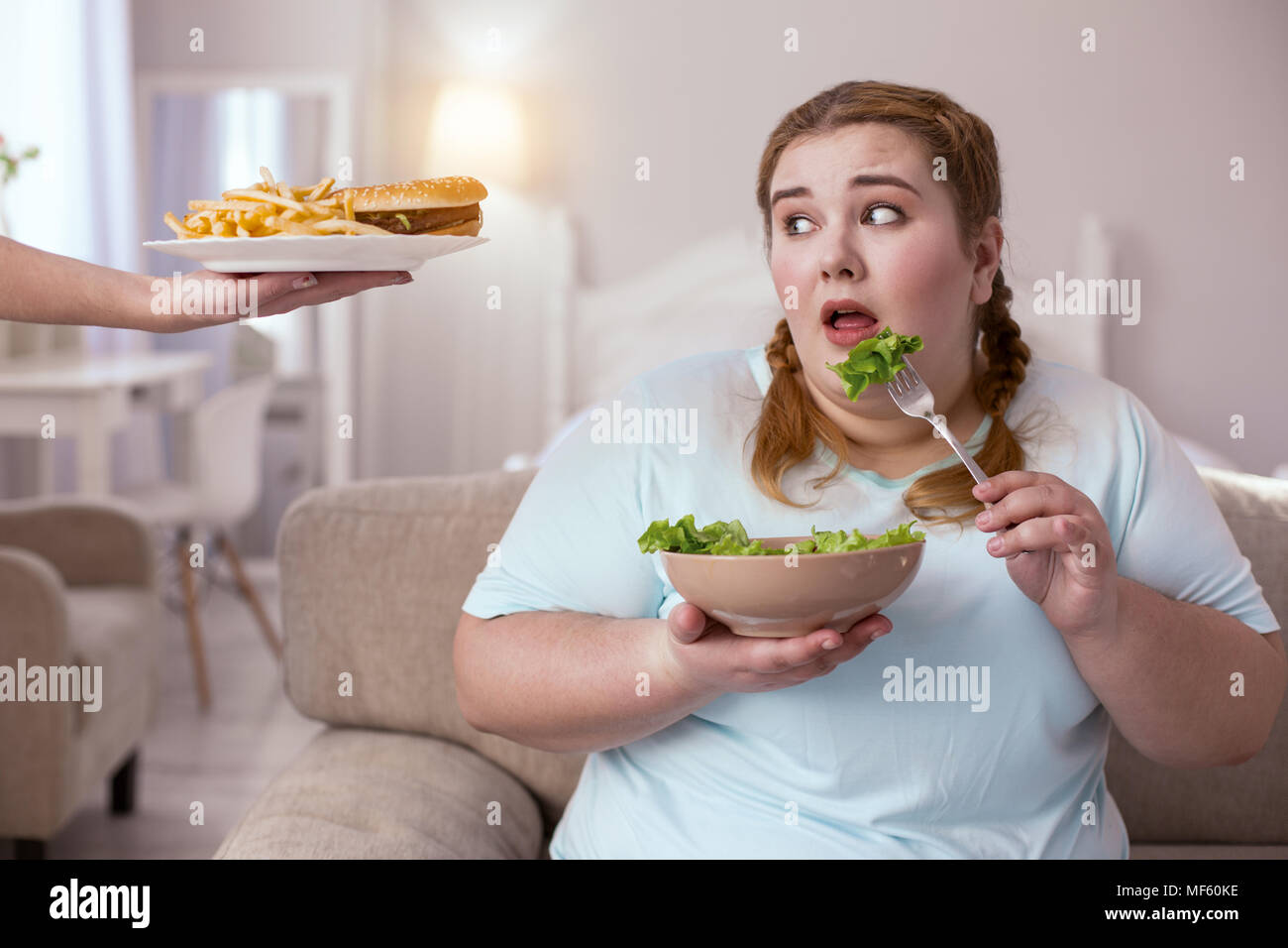 Stout red-head woman deciding which type of food to choose Stock Photo
