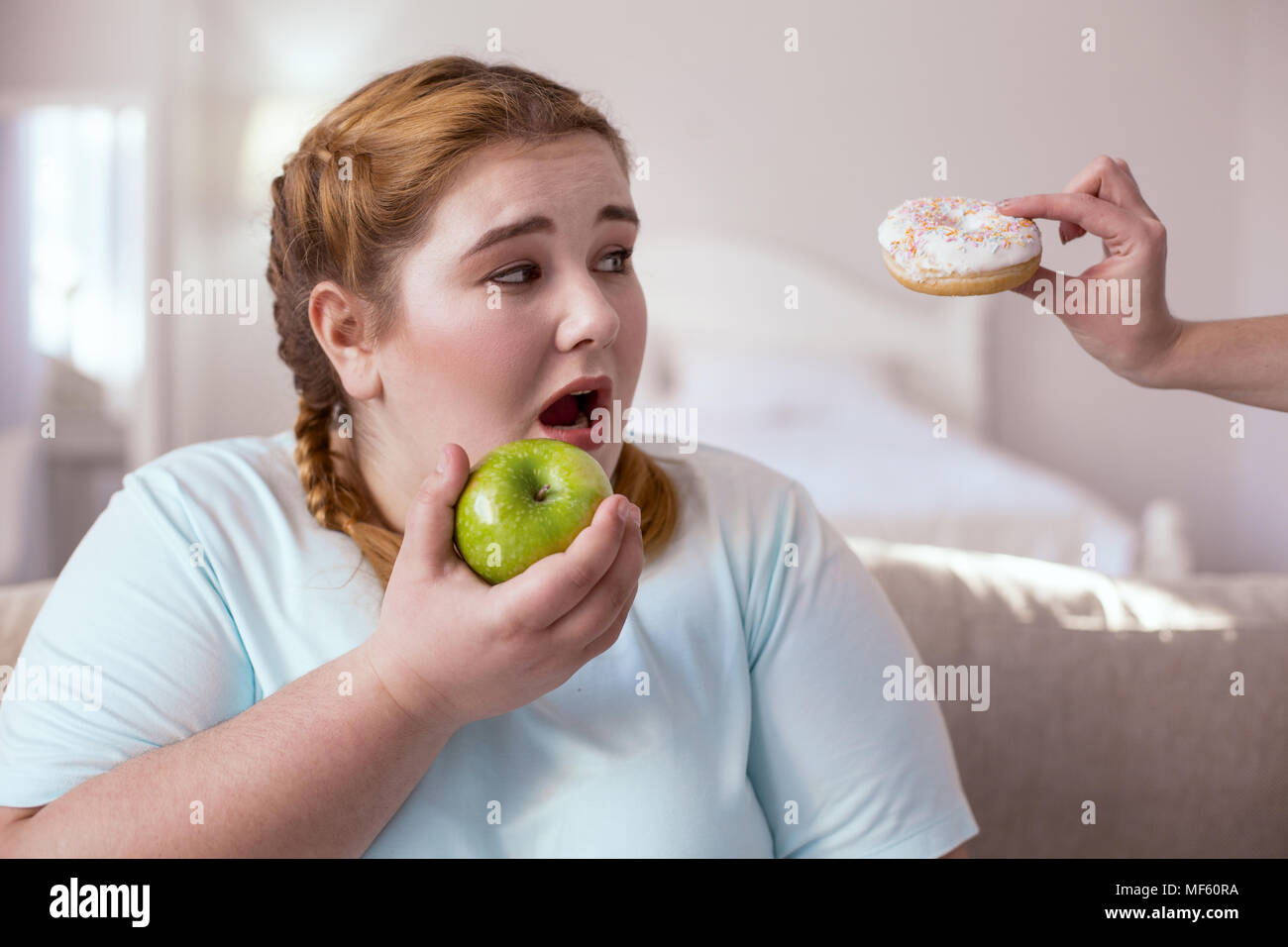 Chubby young woman holding green apple Stock Photo