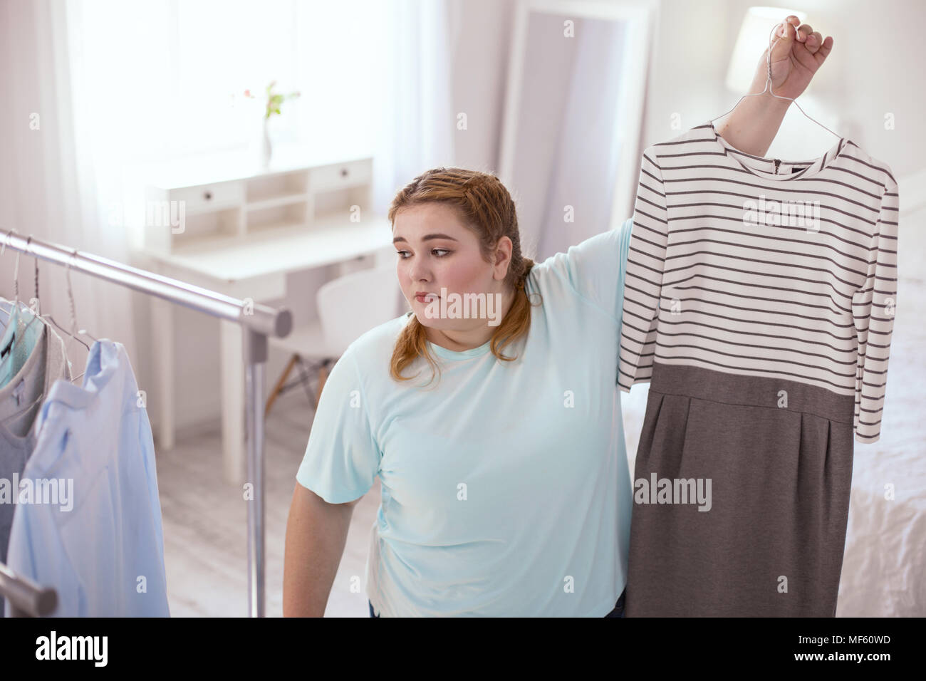 Sad plump woman disappointing in her choice Stock Photo