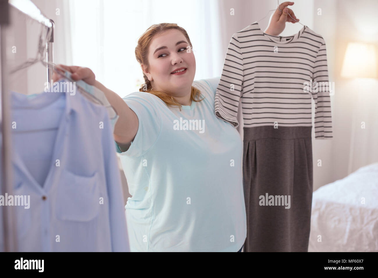 Lovely red-head woman updating her wardrobe Stock Photo