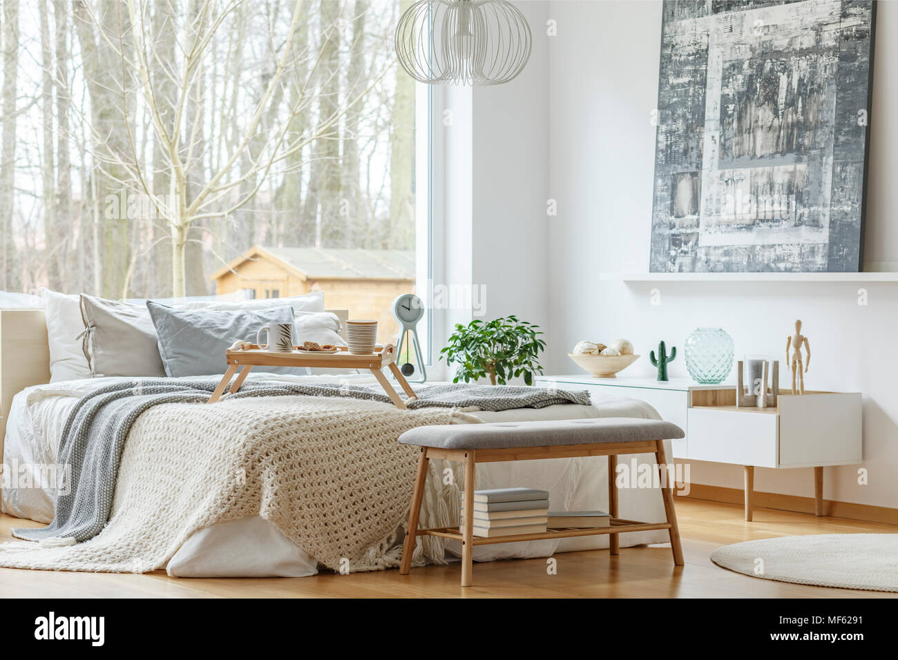 Painting Above White Cupboard In Modern Bedroom Interior With Grey Bench In Front Of Bed Stock Photo Alamy