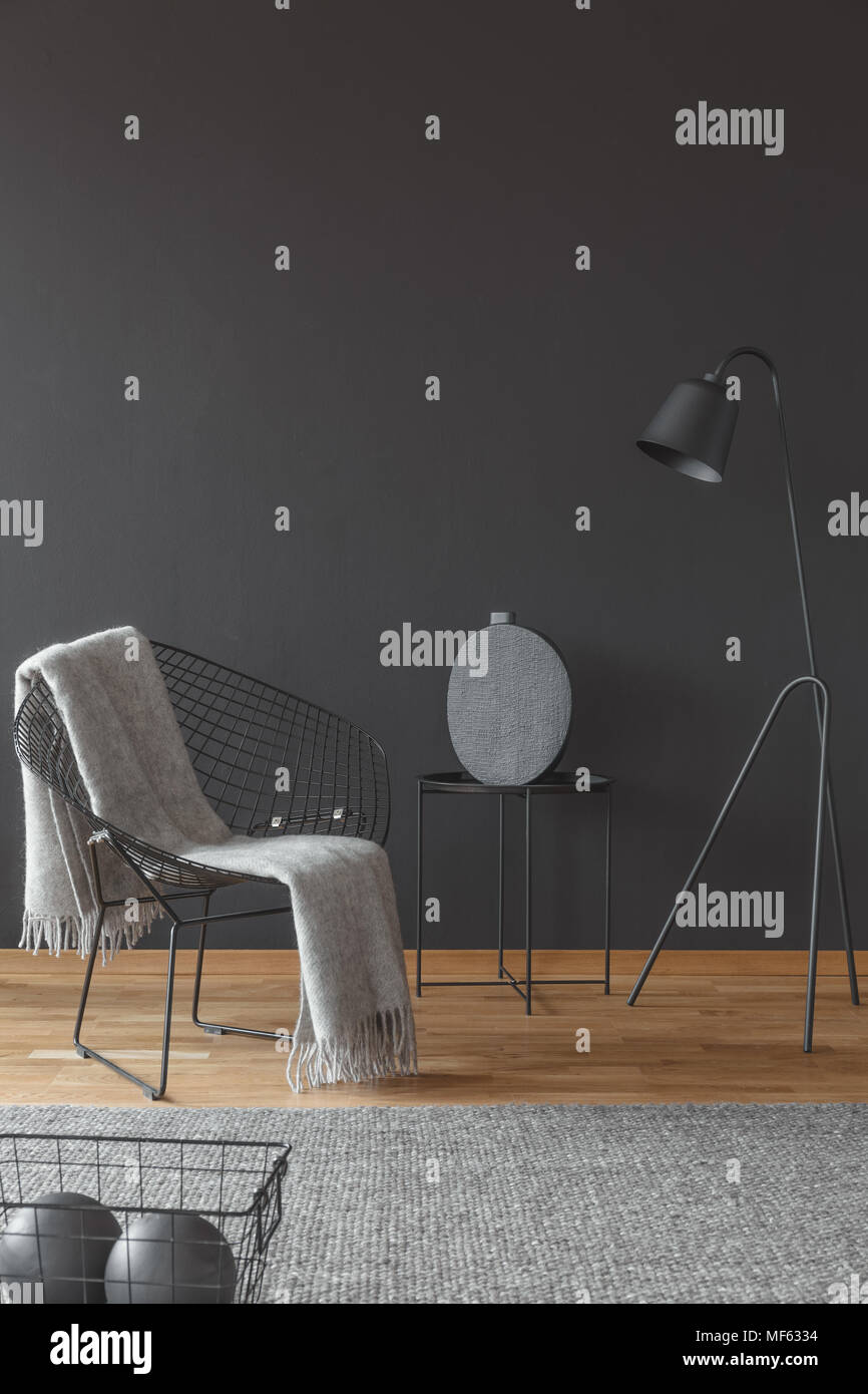 Relaxing reading corner in living room interior with gray blanket on