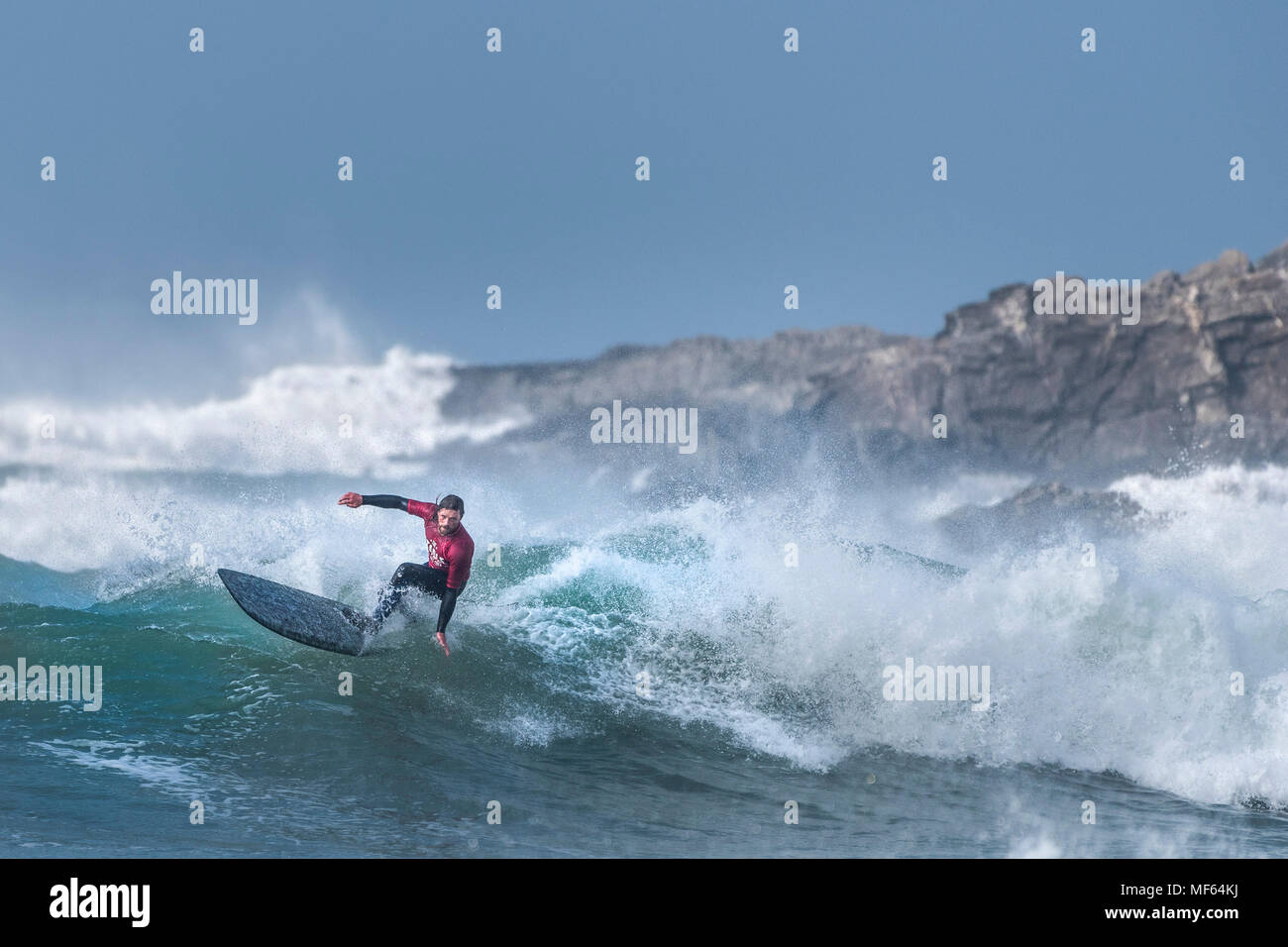 A surfer competing in a longboard surfing competition at Fistral Beach