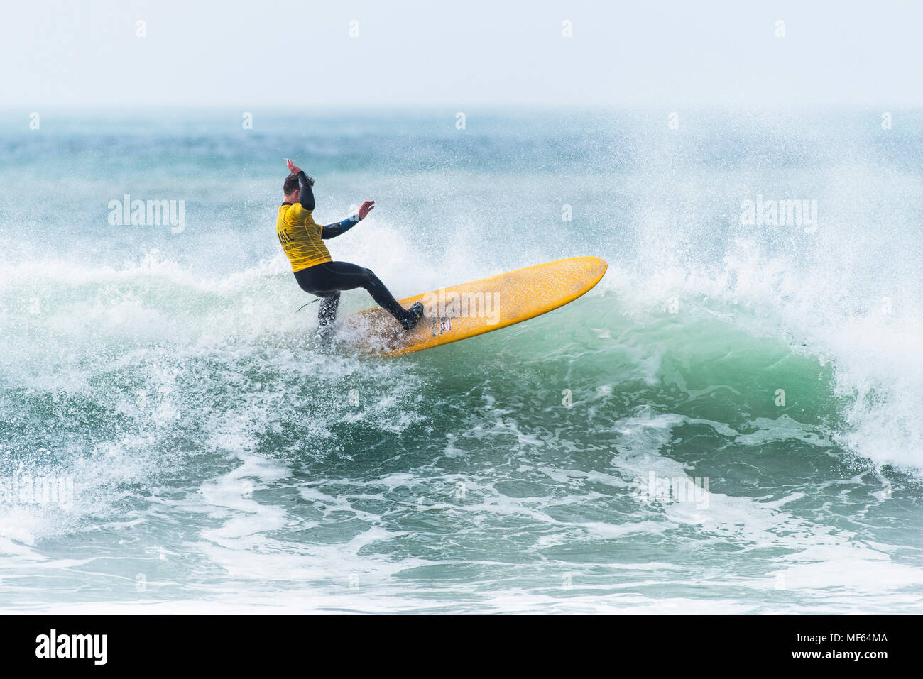 A surfer sompeting in a longboard surfing competition at Fistral Beach; Newquay Cornwall; Stock Photo