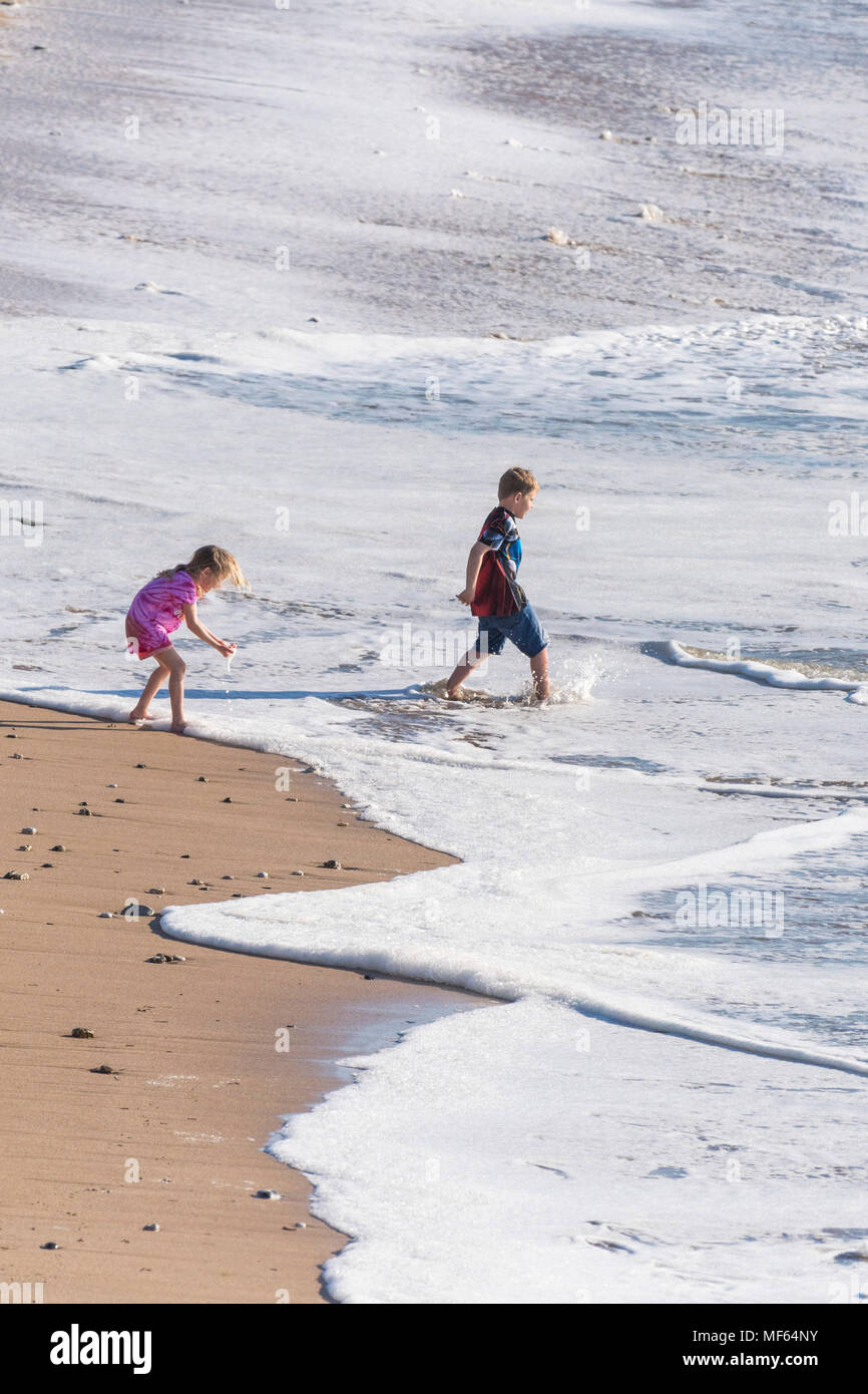 Children on a staycation holiday paddling in the sea at Fistral Beach in Newquay in Cornwall. Stock Photo