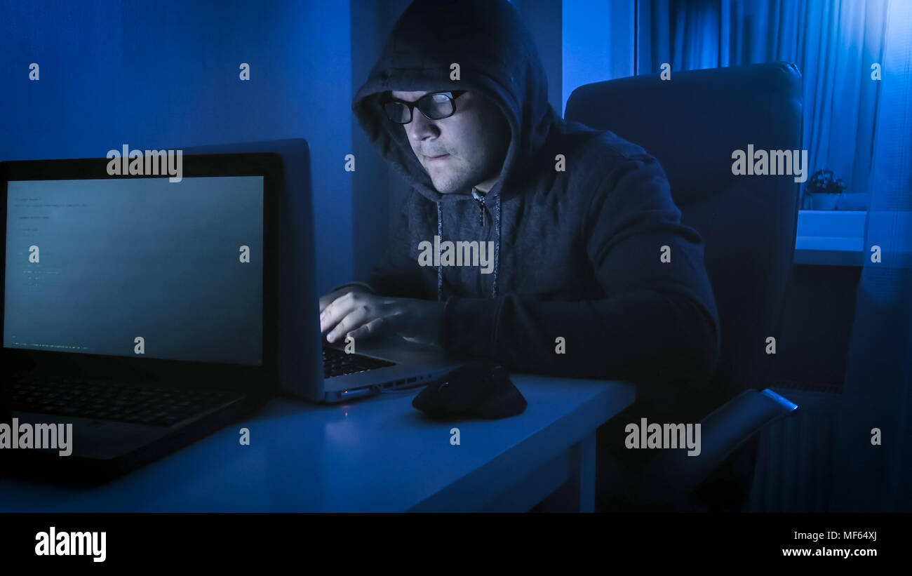 Gang Computer Hooded hacker working on computer hi-res stock photography and images ...