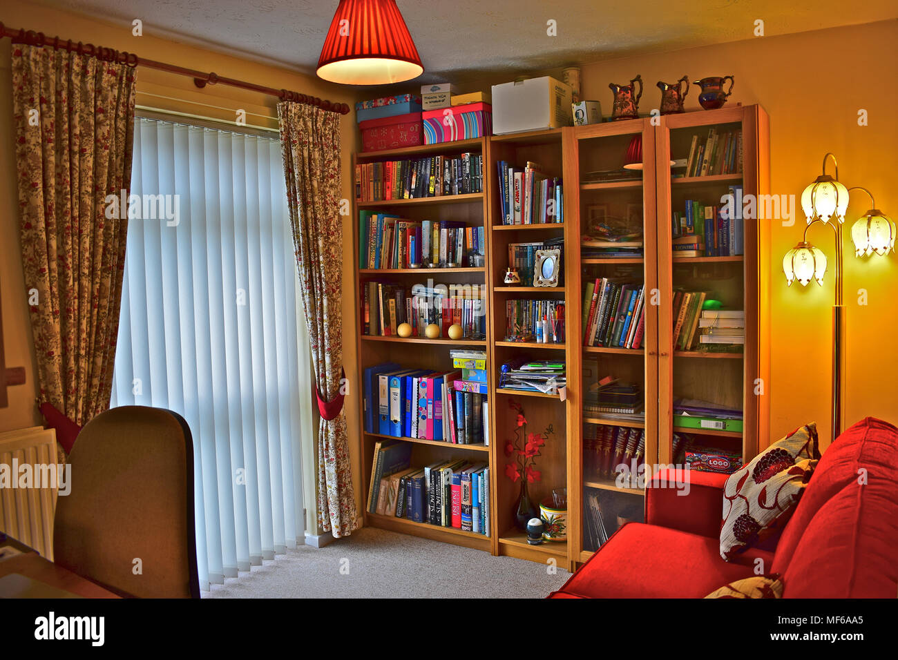 A small study in a modern house which is also used as occasional bedroom with a bed-settee to one side. Stock Photo