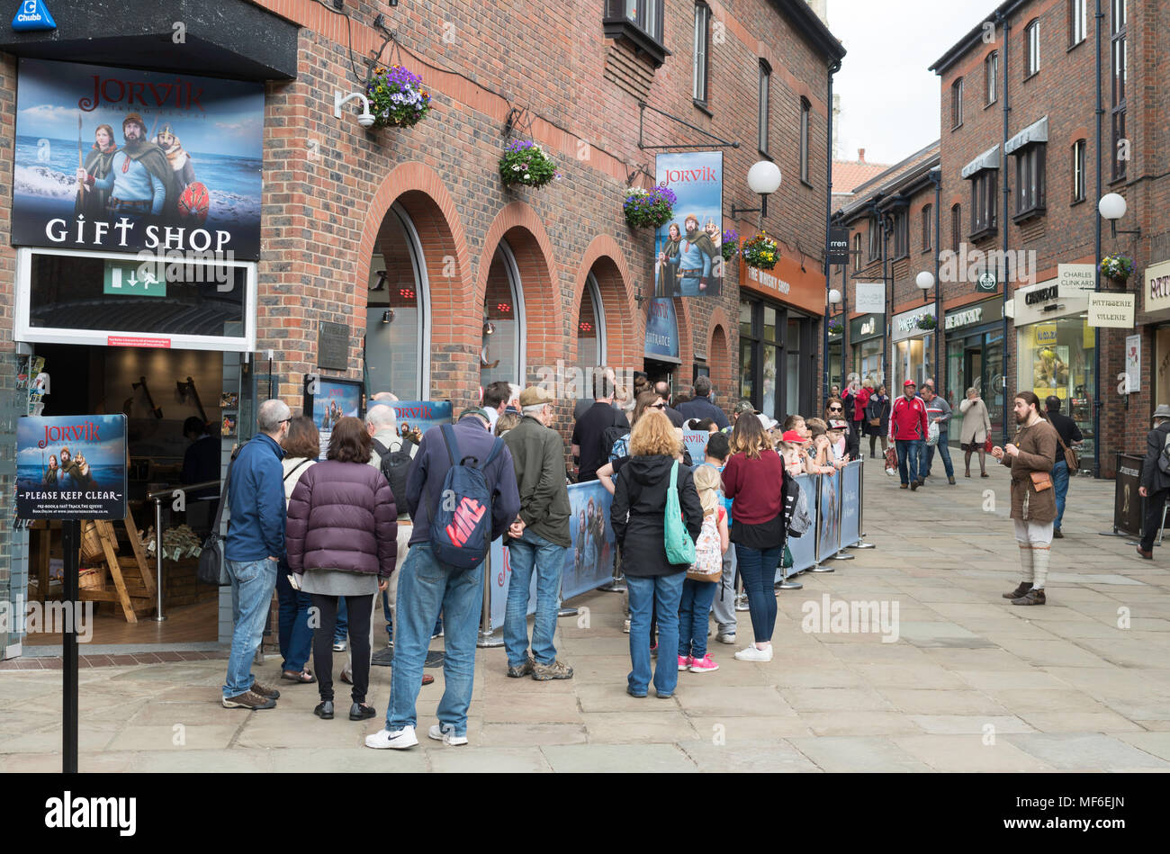 People queuing outside the Jorvik Viking Centre while a re-enactor entertains a group of children, York, Yorkshire, England, UK Stock Photo