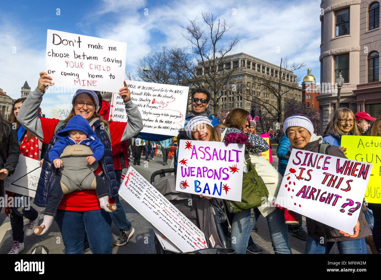 Female teacher, husband and baby holding protest signs. March For Our Lives rally against gun violence  on March 24, 2018 in Washington, DC, USA. Stock Photo