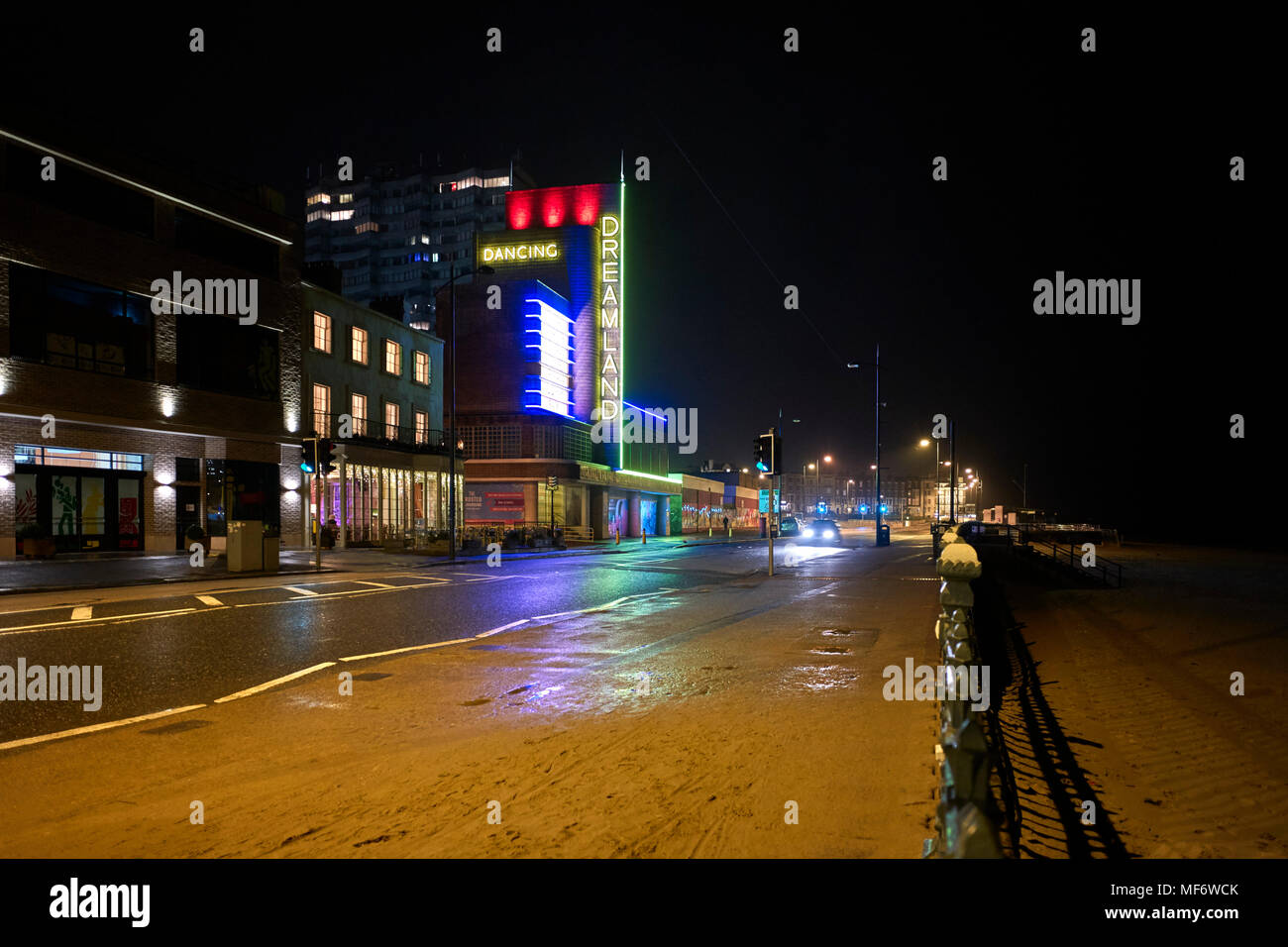Margate seafront at night showing the Dreamland building lit up and sand  across the pavement Stock Photo - Alamy