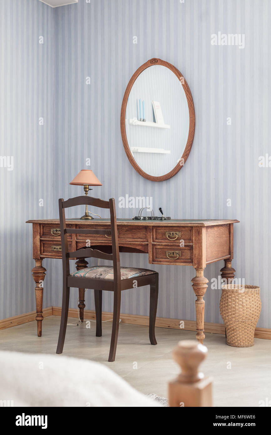 Wooden Desk In Front Of A Mirror In A Bedroom Stock Photo