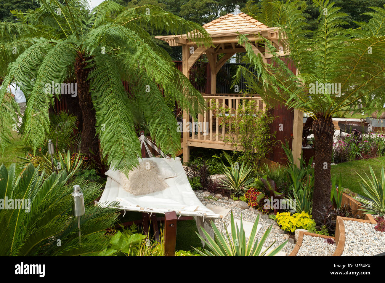 Exotic palms, gazebo, hammock, path & flowers in tropical style show garden - Visit Plantation: Colonial Chic and Bajan Roots. RHS Show Tatton Park. Stock Photo