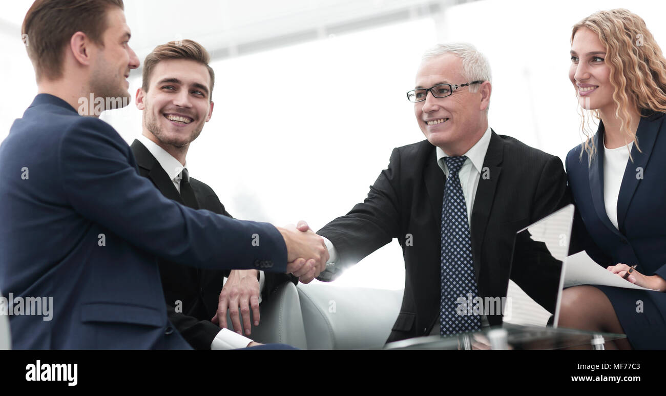 Partners concluding deal and shaking hands in the presence of team ...