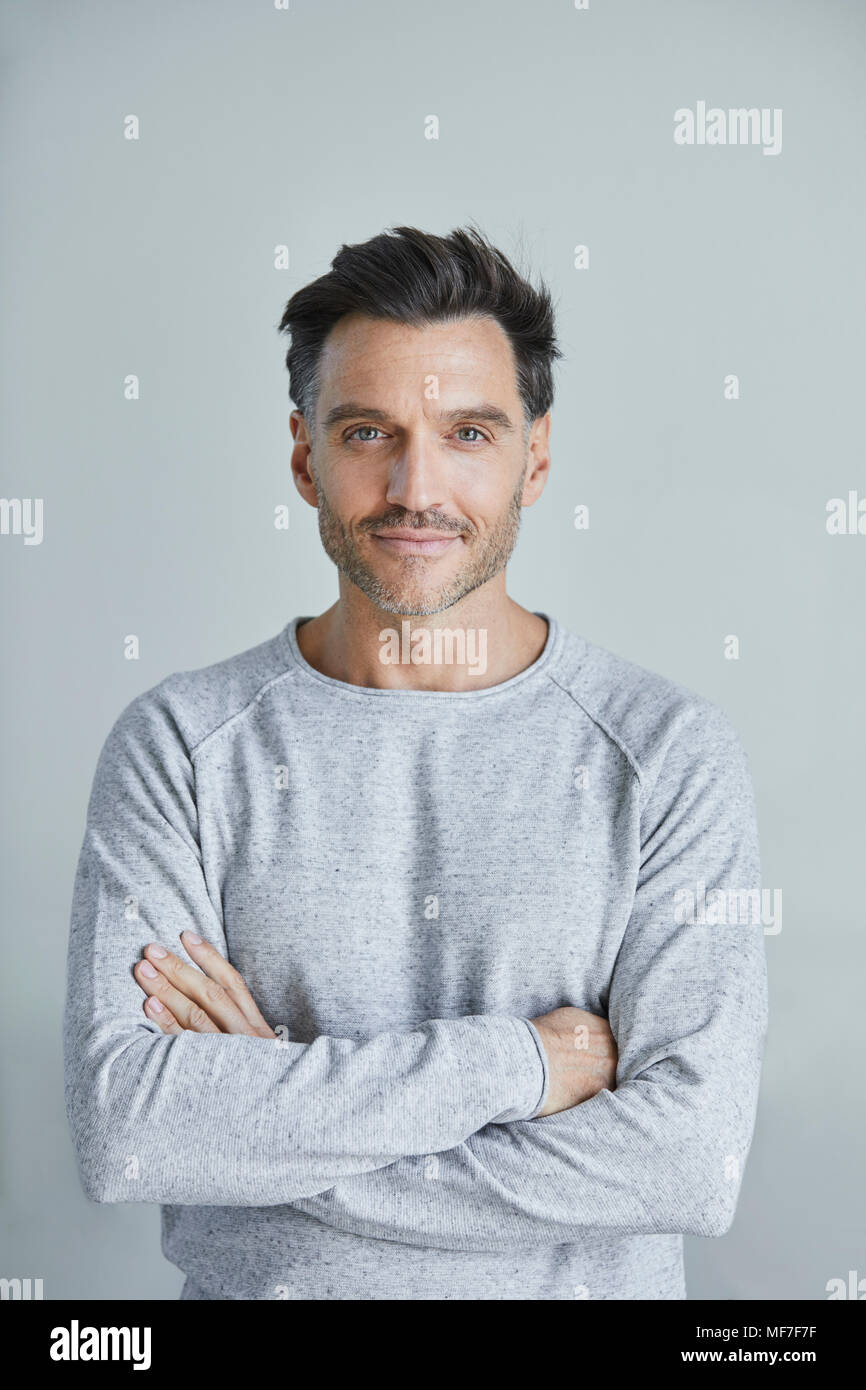 Portrait of smiling man with stubble wearing grey sweatshirt Stock Photo